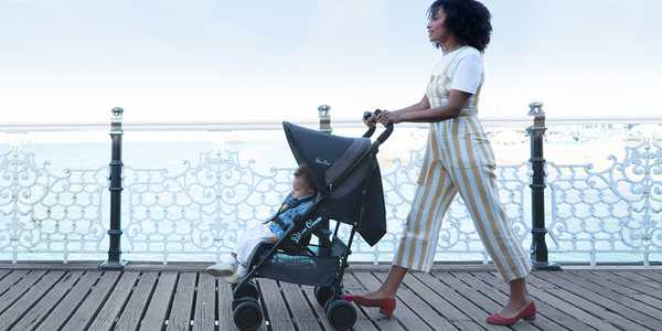 A woman walking her toddler in a blue coloured Silver Cross stroller.